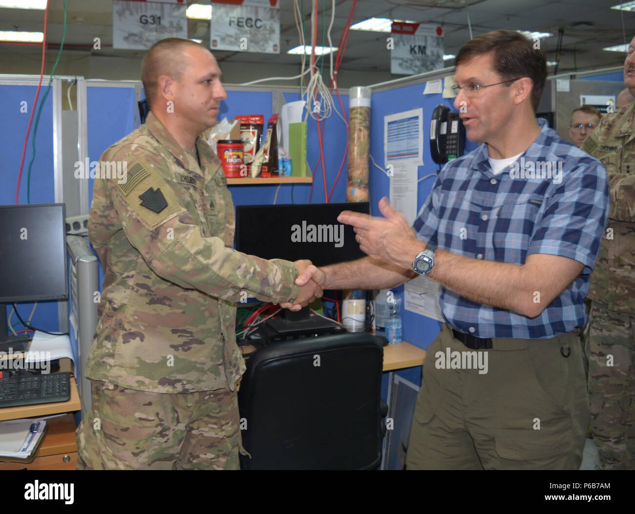 CAMP ARIFJAN, Kuwait — Secretary of the Army Dr. Mark Esper presents a coin to Staff Sgt. Justin Schulmeister, space operations noncommissioned officer, 28th Infantry Division, on June 21, 2018. Schulmeister was recognized for his successful integration of space operations into the Task Force Spartan mission. (U.S. Army photo by Lt. Col. Keith Hickox) Stock Photo