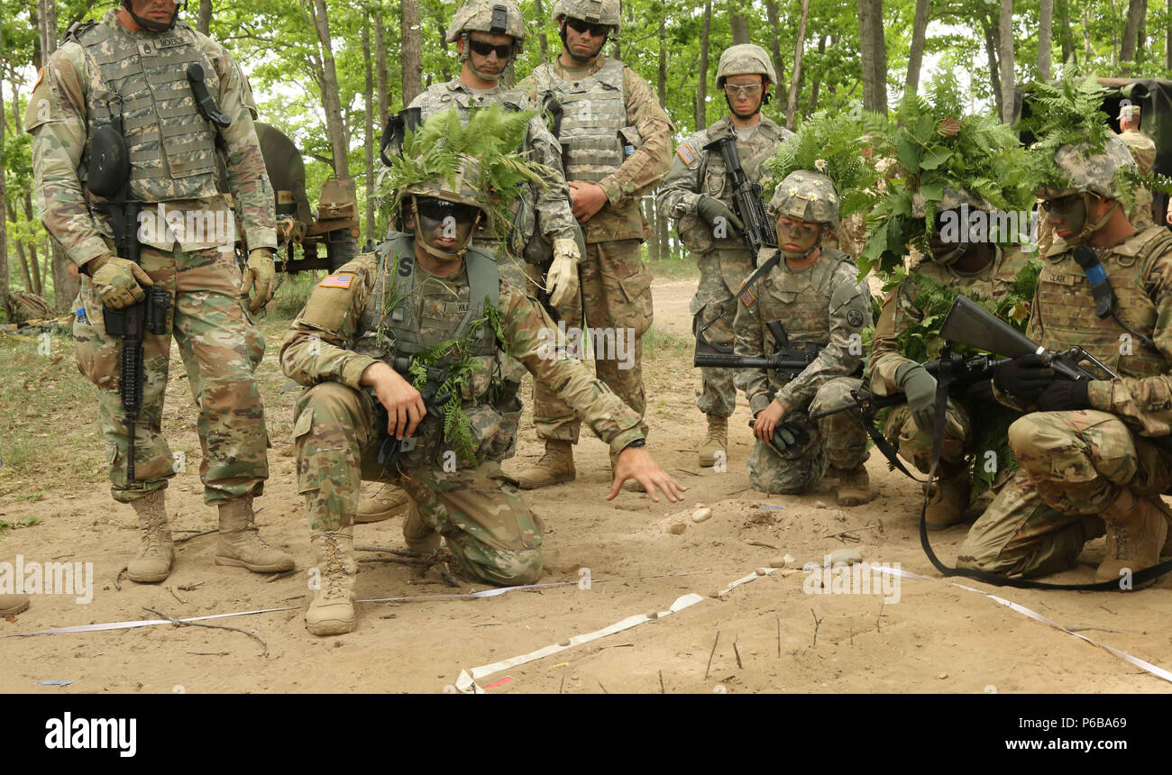 2nd. Lt. Seth Kilian, a platoon leader for the 1194th Engineer Company out of Chillicothe, Ohio, uses a sand table to explain the terrain and route during a platoon defense training exercise June 22 at the Camp Grayling Joint Maneuver Training Center in Grayling, Mich. The goal of the exercise was to improve unit communication and tactical skills. (Ohio Army National Guard photo by Spc. Emilie Sheridan/Released) Stock Photo