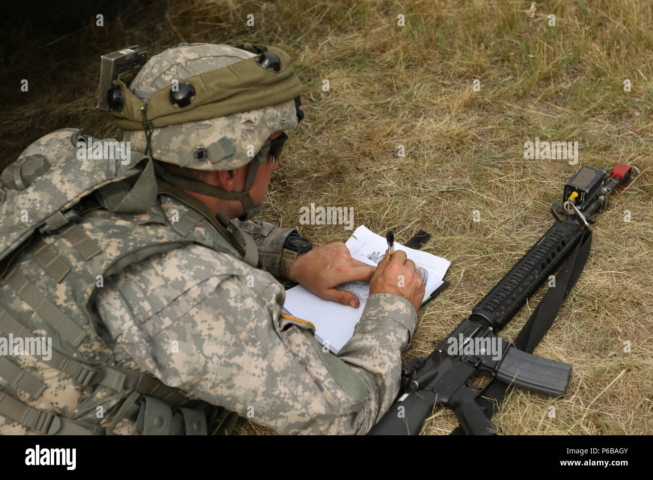 Sgt. Adam Knowles, a heavy motor transport operator of the 1487th Motor Transportation Company and a Wooster, Ohio native, fills out a range card with artistic flair June 22 at the Camp Grayling Joint Maneuver Training Center in Grayling, Mich. Range cards are used to sketch the terrain in a Soldier's assigned sector of fire when defending an area of unit operations. (Ohio Army National Guard photo by Sgt. Joanna Bradshaw/Released) Stock Photo