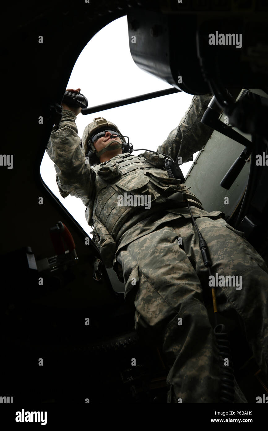 Spc. Brandyn Pailin of the 1487th Transportation Company and native of Elida, Ohio, prepares to fire an M240 machine gun from the turret of a specially armored High Mobility Multipurpose Wheeled Vehicle (HMMWV) June 24 at the Camp Grayling Joint Maneuver Training Center in Grayling, Mich. Soldiers of many Ohio National Guard units must successfully complete a barrage of tests with these mobile weapons systems. (U.S. Army photo by Sgt. Joanna Bradshaw/Released) Stock Photo