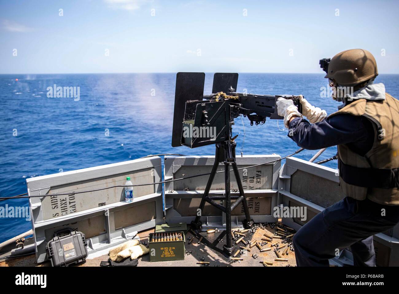 180623-N-KW492-0112 ATLANTIC OCEAN (June 23, 2018) Aviation Ordnanceman 3rd Class Alex Blanco fires a .50-caliber machine gun during an integrated live-fire weapons exercise aboard the Wasp-class amphibious assault ship USS Kearsarge (LHD 3) as part of Surface Warfare Advanced Tactical Training (SWATT). The Kearsarge Amphibious Ready Group is completing the Navy’s first East Coast SWATT exercise. SWATT is led by the Naval Surface and Mine Warfighting Development Center and is designed to increase warfighting proficiency, lethality, and interoperability of participating units. (U.S. Navy Photo  Stock Photo