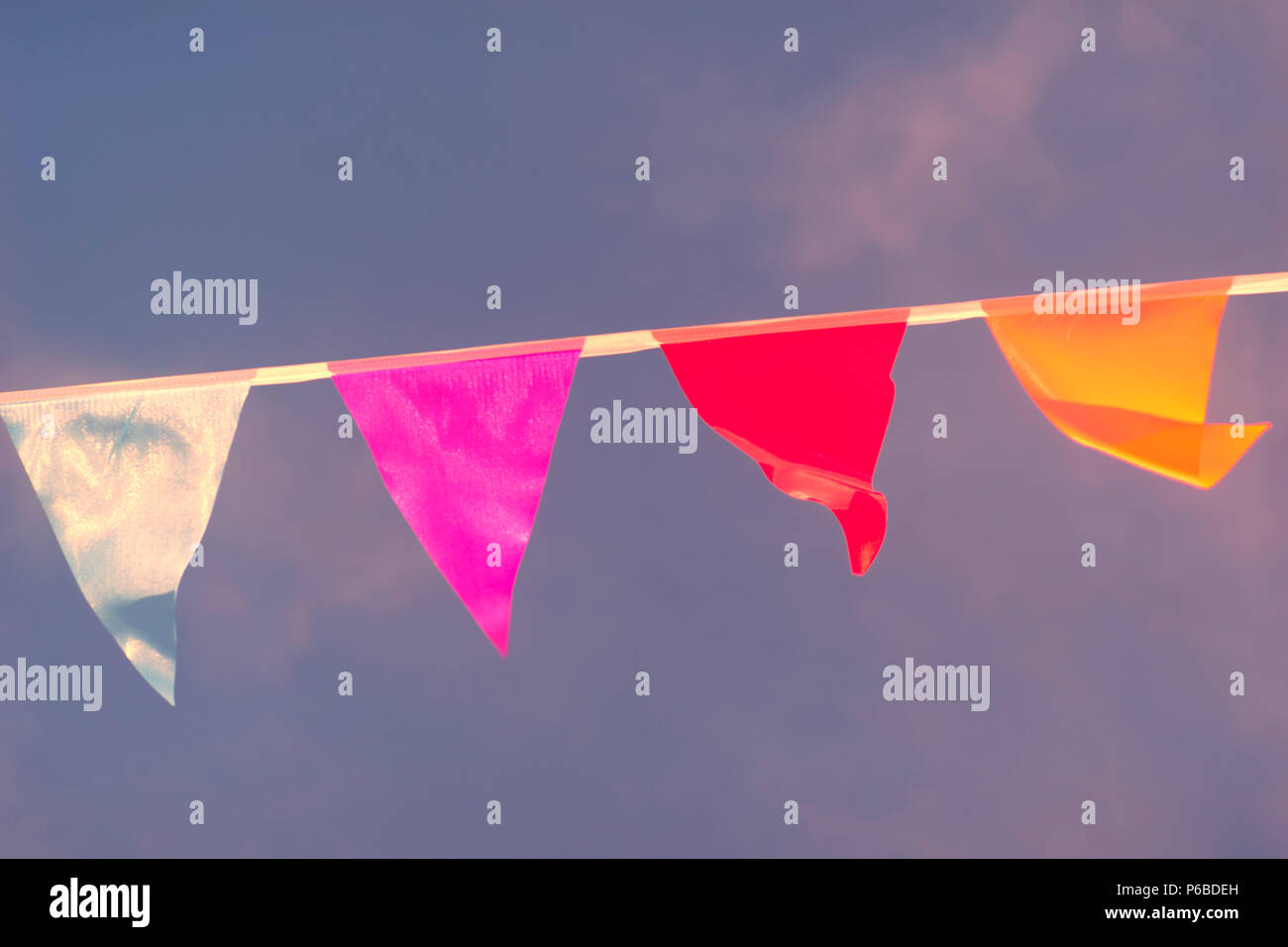 Triangular flags of different colors are sewn in a rope and sway in the