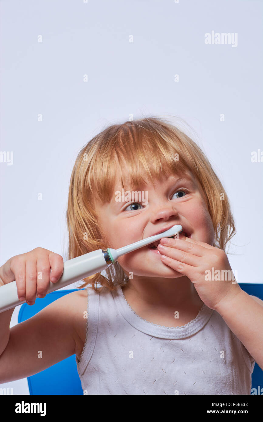 baby brushing her teeth with an electric brush Stock Photo Alamy