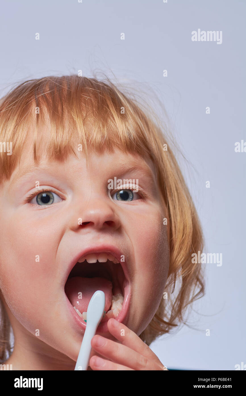 baby brushing her teeth with an electric brush Stock Photo Alamy