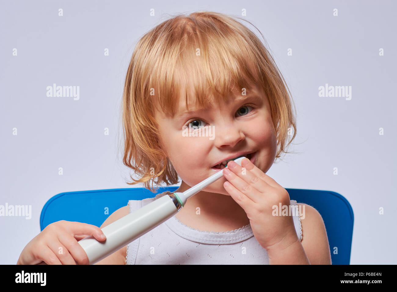 baby brushing her teeth with an electric brush Stock Photo Alamy