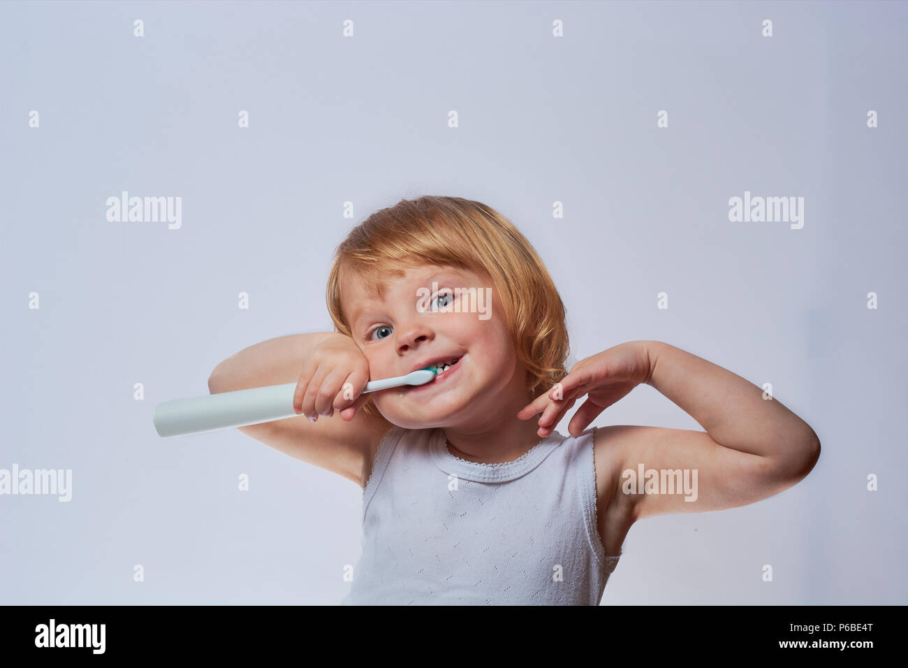 baby brushing her teeth with an electric brush Stock Photo Alamy