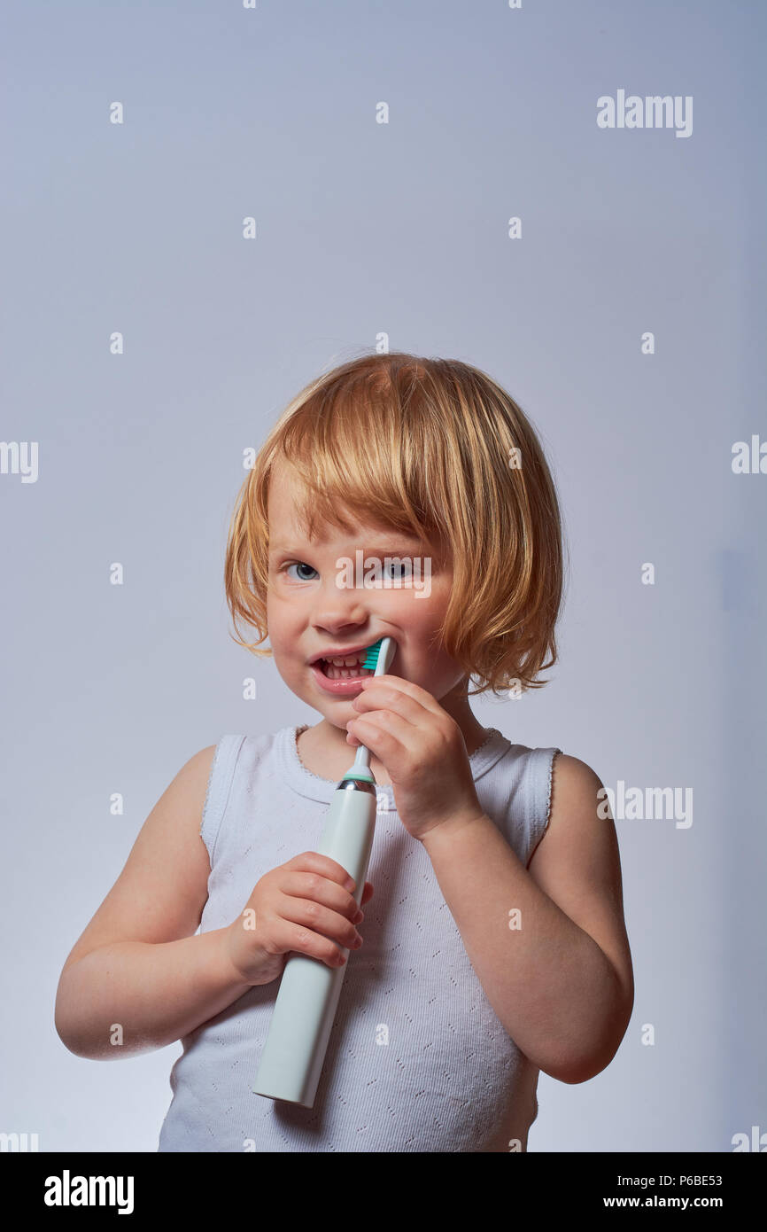 baby brushing her teeth with an electric brush Stock Photo Alamy