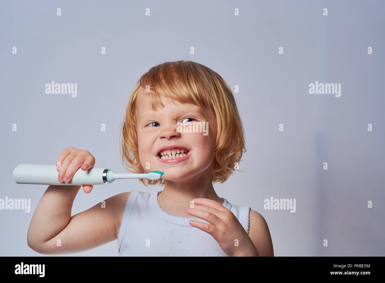 baby brushing her teeth with an electric brush Stock Photo Alamy