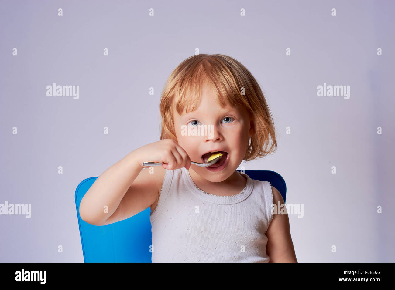 baby eating ice cream at the table spoon by herself Stock Photo Alamy