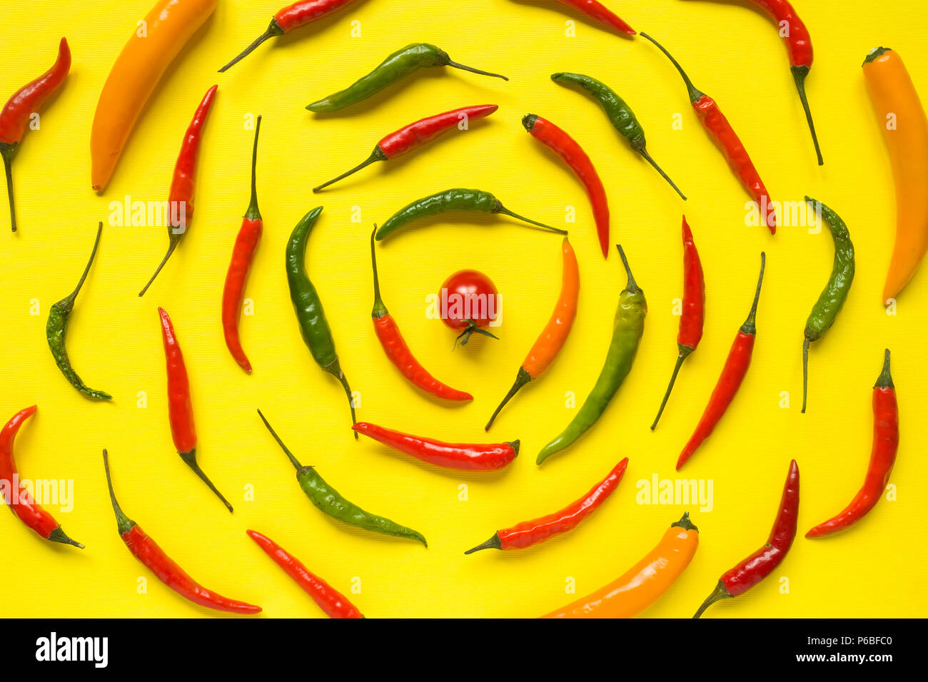 Assorted chili pepper tomato cherry On yellow bright background. Stock Photo