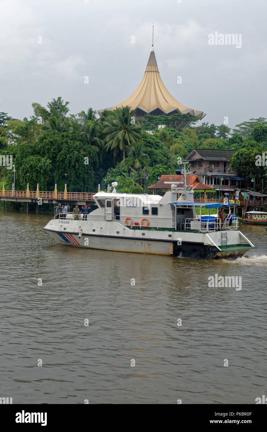 river police boat passing the State Legislative Assembly building, Sarawak river, Kuching, Borneo Stock Photo