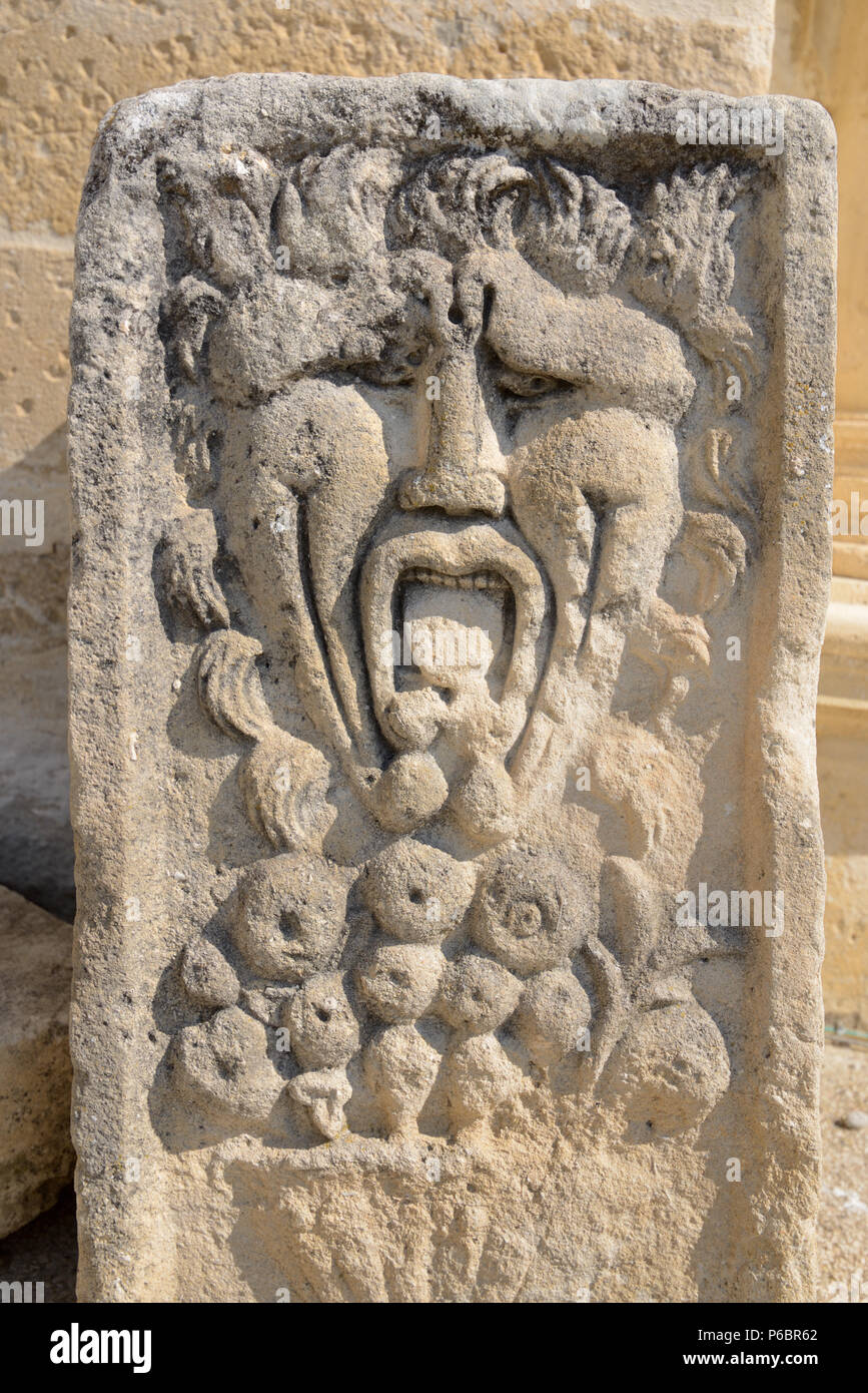 Green Man Stone Carving, Strange Carved Stone Face or Theatre Mask in Courtyard of Grignan Château Drôme France Stock Photo
