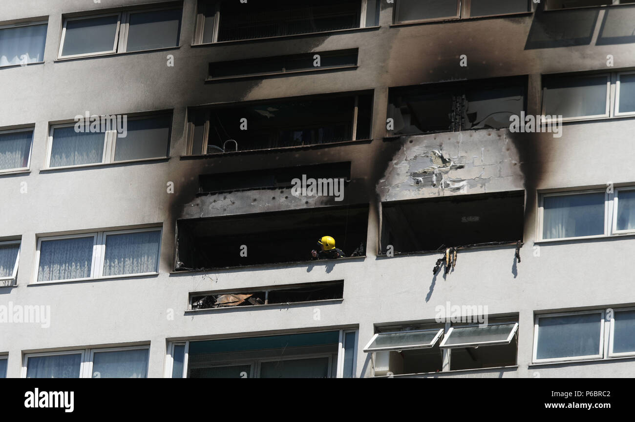 A fire fighter looks at the damage to the outside of a high-rise block in Wellington Way, Mile End, in east London, after a fire broke-out in a 12th floor flat. Stock Photo