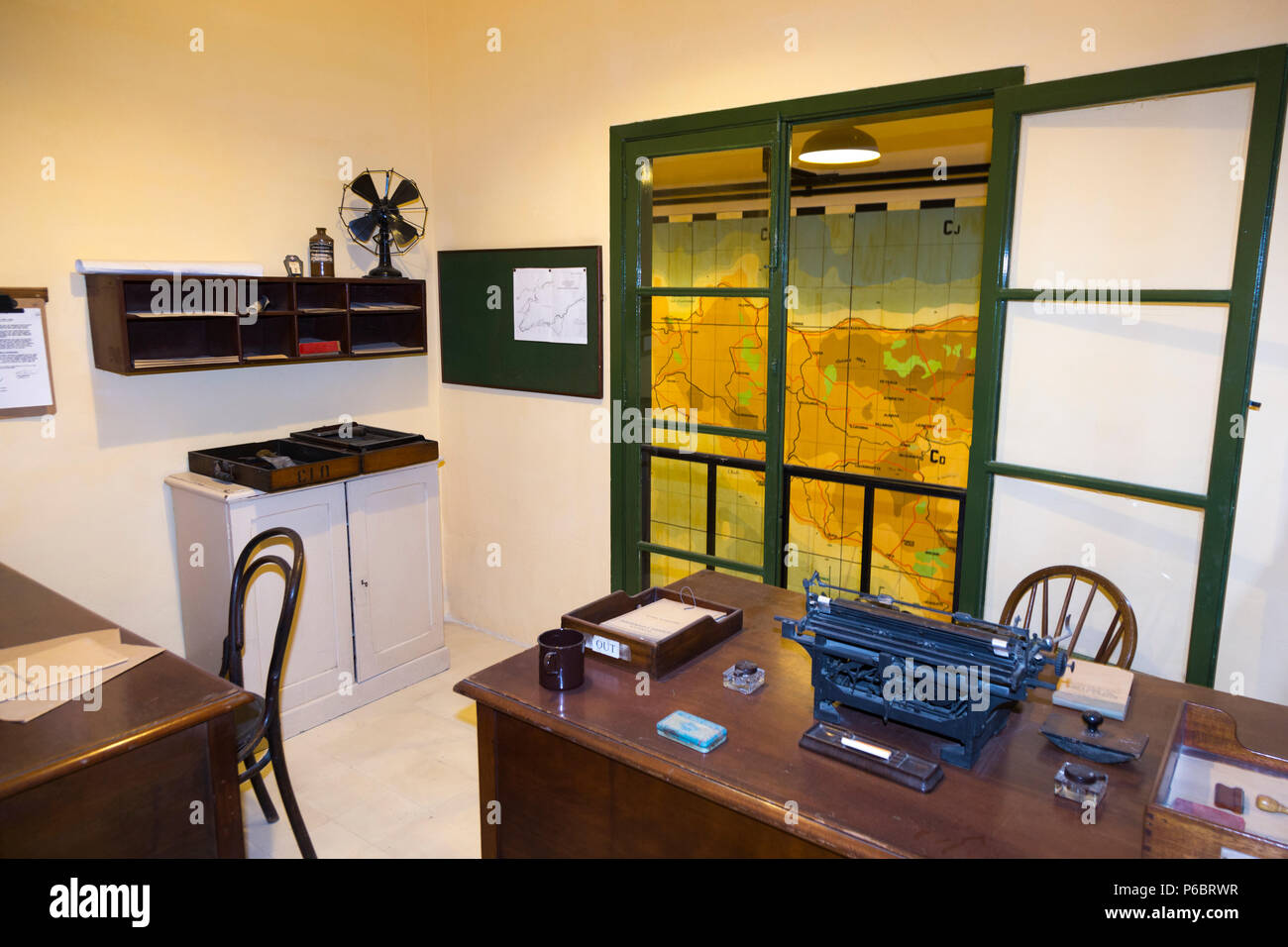 Office with vintage desk, chair and typewriter, and window overlooking map of the island of