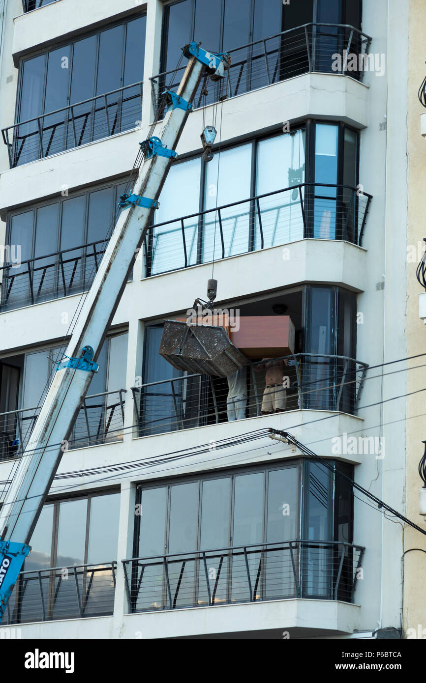 An apparently highly unsafe manoeuvre to remove furniture from a high