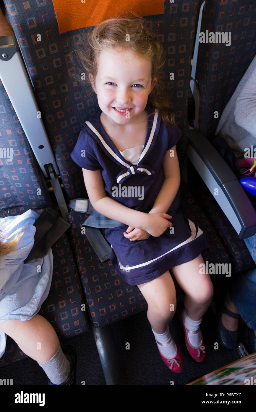 Child / children / girl aged 5 years old / five year old going on holiday / vacation / flying on an Airbus air plane / airplane / aeroplane flight. (91) Stock Photo