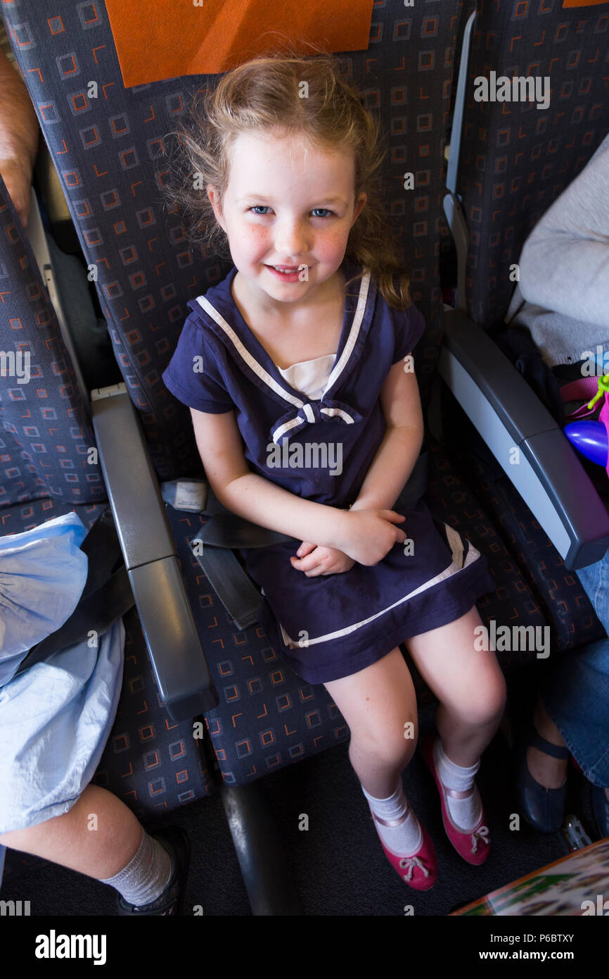 Child / children / girl aged 5 years old / five year old going on holiday / vacation / flying on an Airbus air plane / airplane / aeroplane flight. (91) Stock Photo