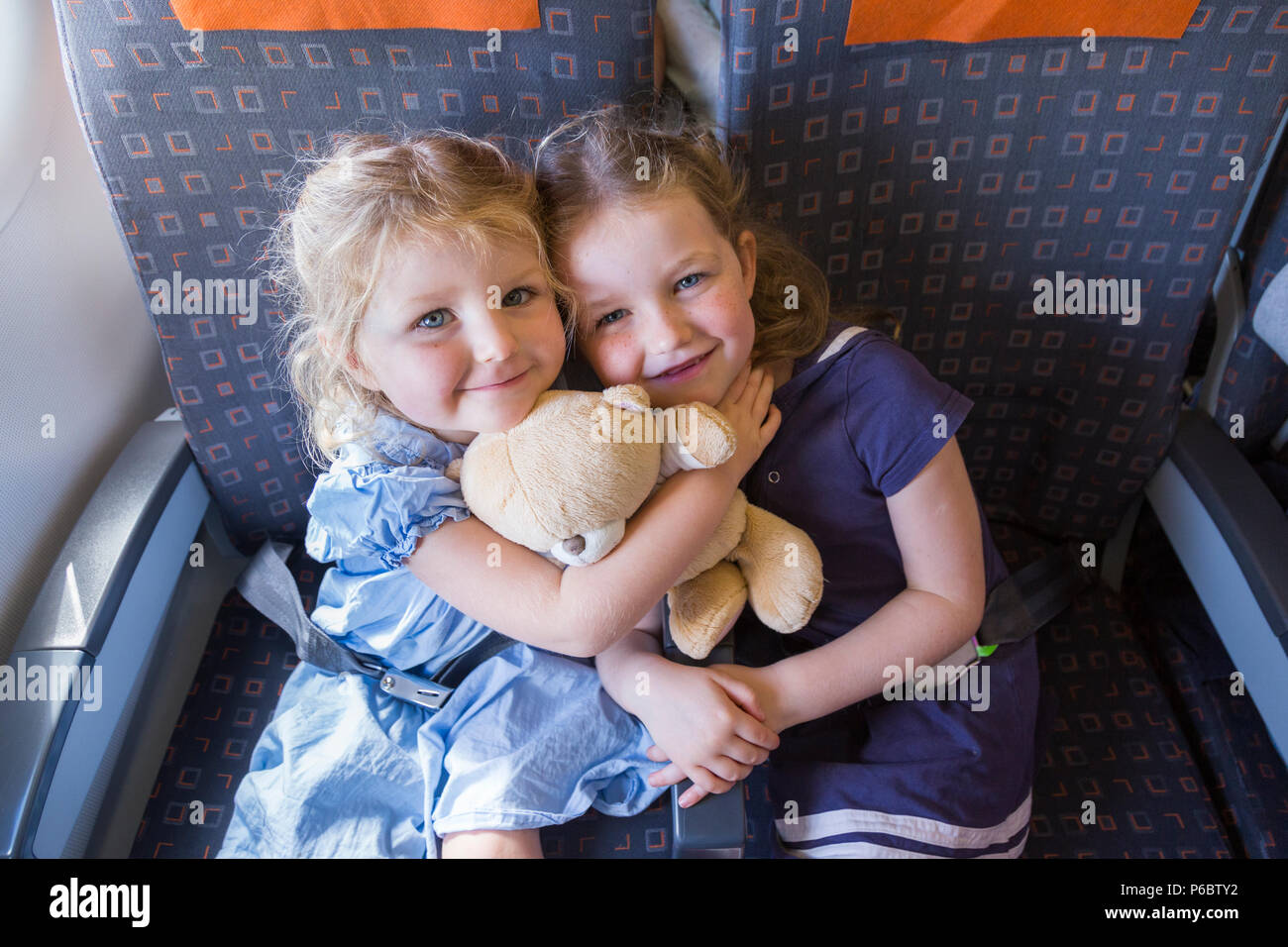 Child sibling sibling children / two sisters aged 3 and 5 going on holiday / vacation / flying on Airbus air plane / airplane / aeroplane flight (91) Stock Photo