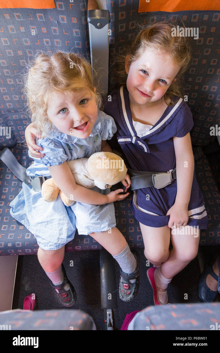 Child sibling sibling children / two sisters aged 3 and 5 going on holiday / vacation / flying on Airbus air plane / airplane / aeroplane flight (91 Stock Photo
