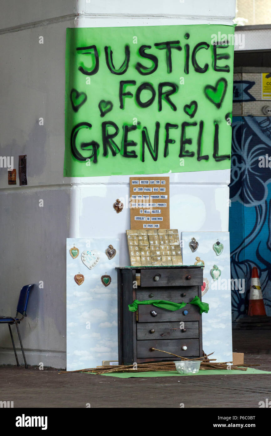 The first anniversary of the 24-storey Grenfell Tower block of public housing flats fire which claimed 72 lives. Justice for Grenfell sign near a makeshift memorial under the Westway flyover.  South Kensington, London, UK, 14th June 2018. Stock Photo