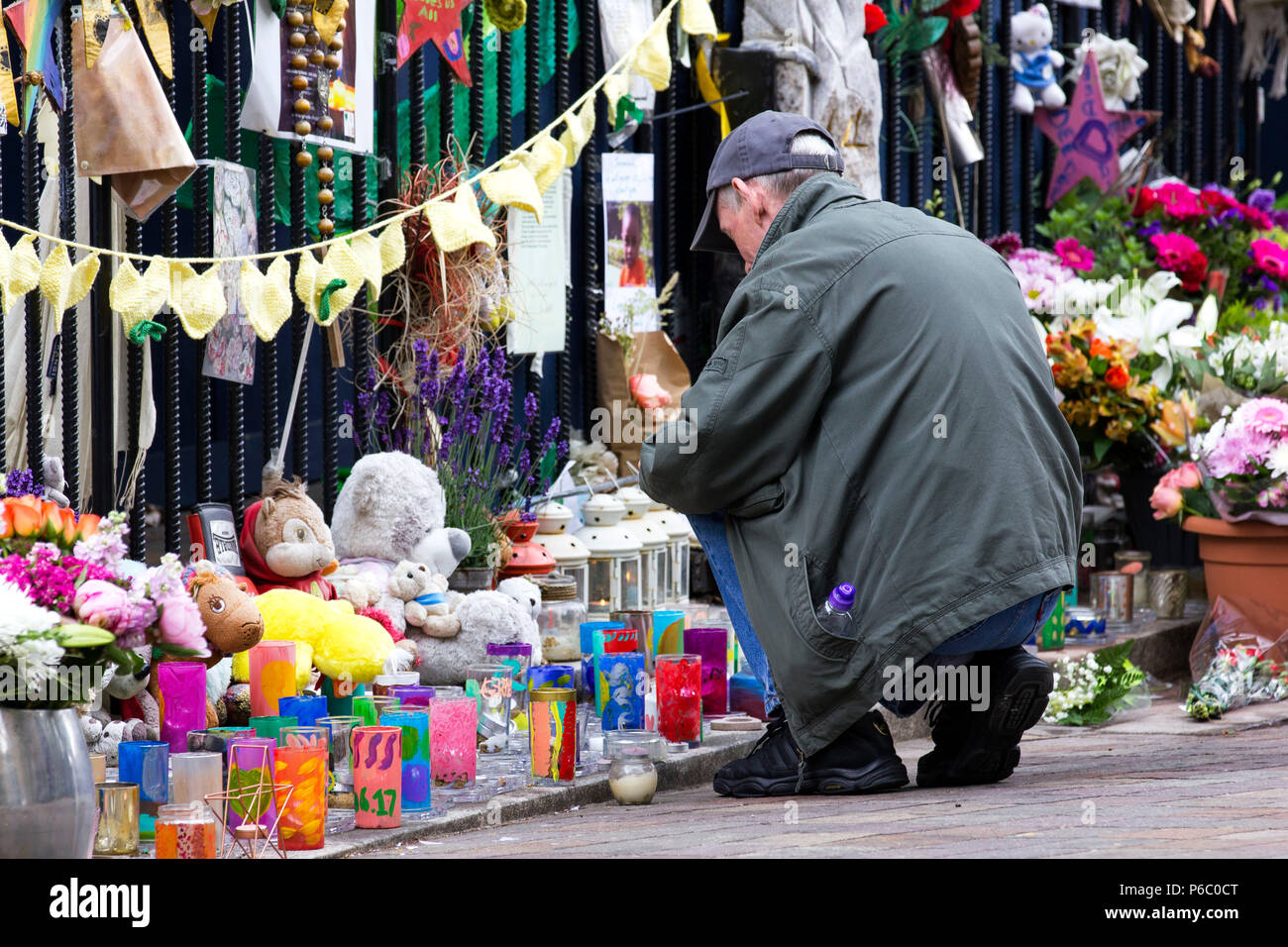 The first anniversary of the 24-storey Grenfell Tower block of public housing flats fire which claimed 72 lives. Man paying his respects at a memorial outside a church near the tower block.  South Kensington, London, UK, 14th June 2018. Stock Photo