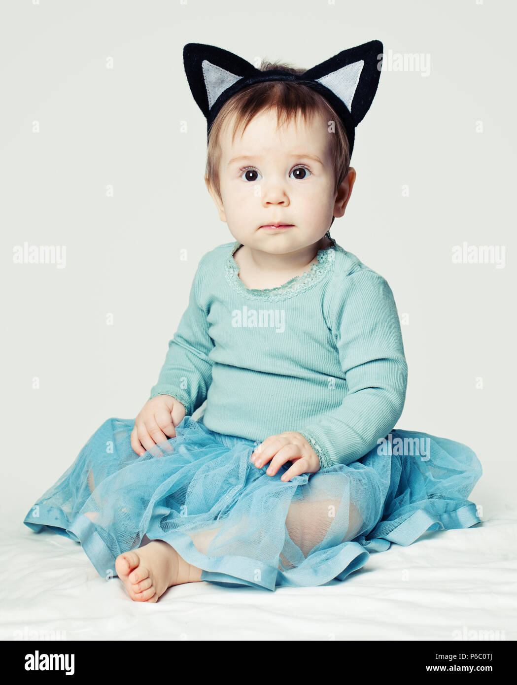 Little baby girl in blue skirt on white Stock Photo - Alamy