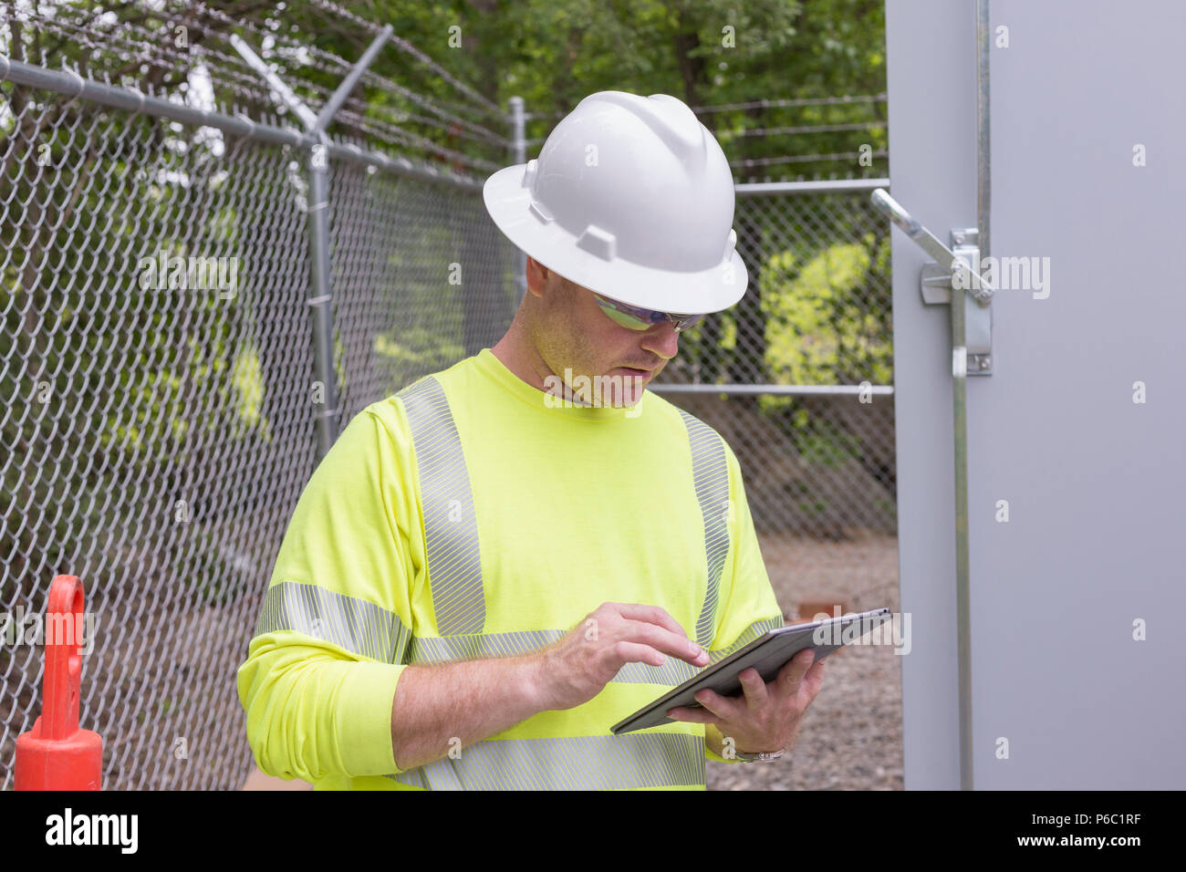 Engineer at an electric power plant checking his tablet Stock Photo