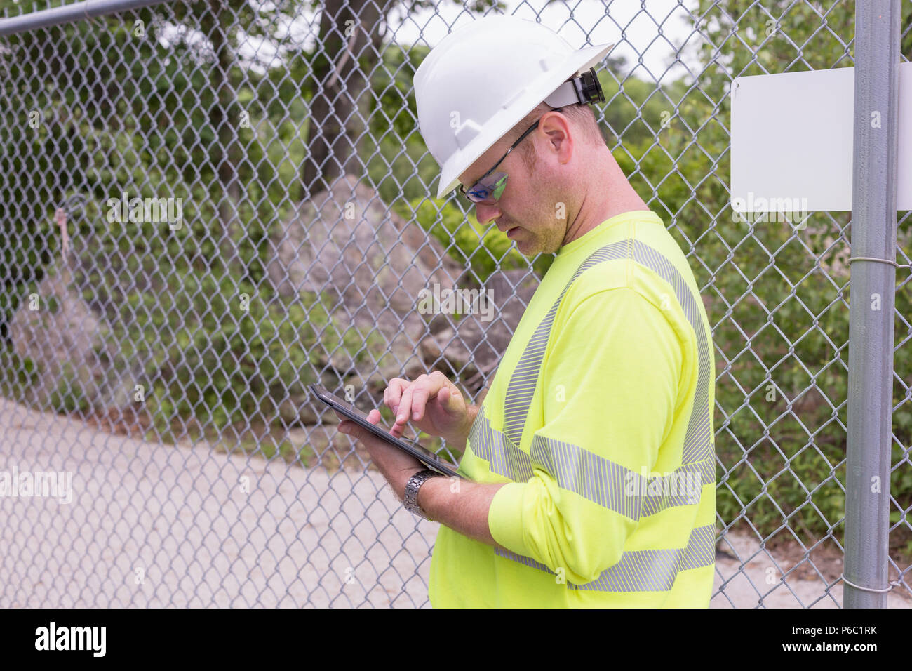 Engineer at an electric power plant checking his tablet Stock Photo