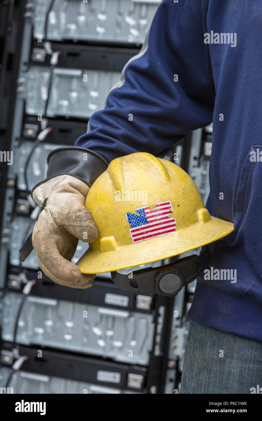 Engineer carrying hard hat with rubber protective gloves Stock Photo