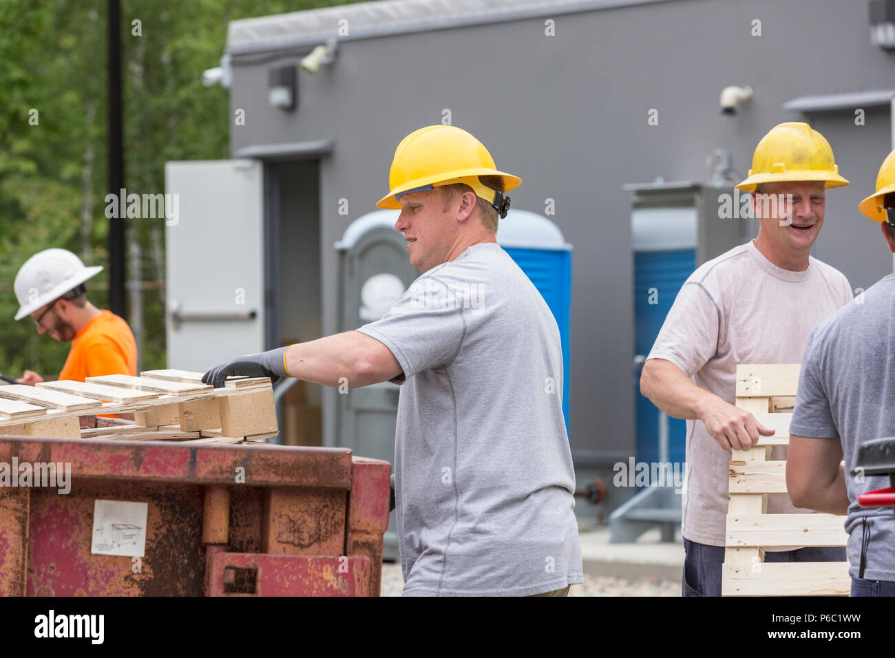 Engineers putting pallets into a dumpster Stock Photo Alamy