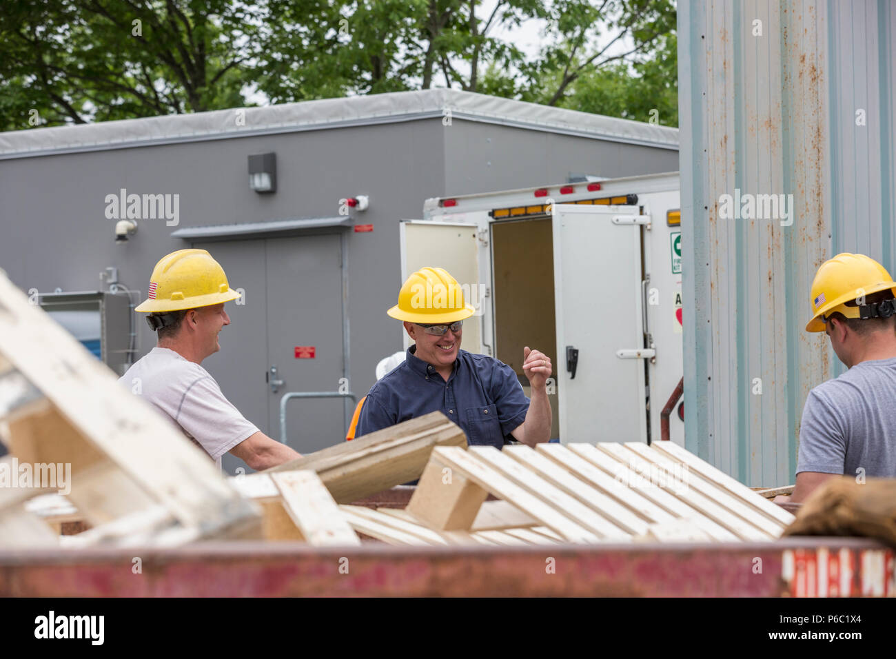 Engineers putting pallets into a dumpster Stock Photo Alamy