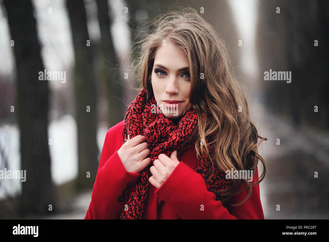Smiling woman in red scarf walking in park. Perfect female face closeup Stock Photo