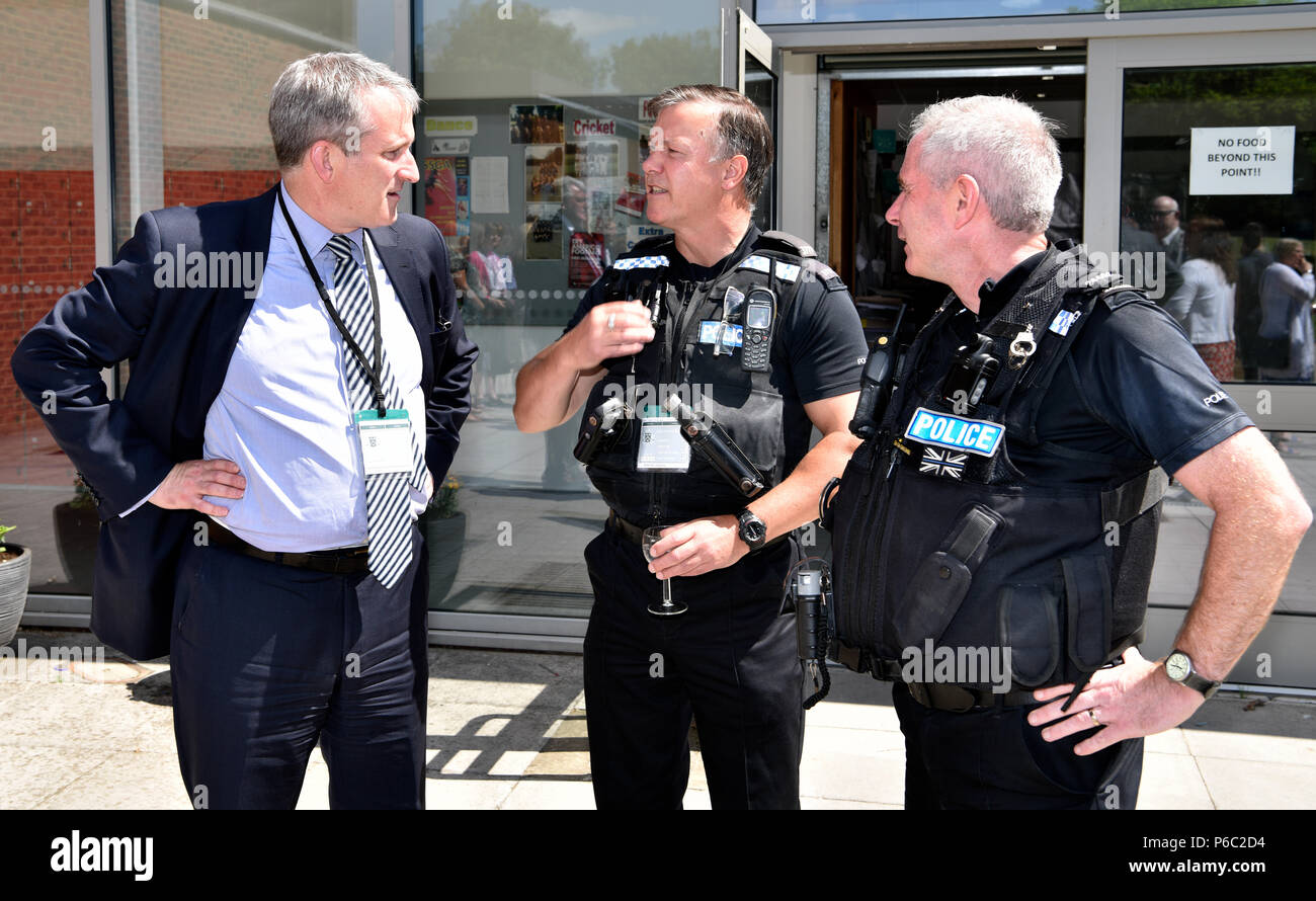 Damian Hinds (left), Conservative MP for East Hampshire , in conversation with police officers during a visit to a school to open new refectory, Alton. Stock Photo