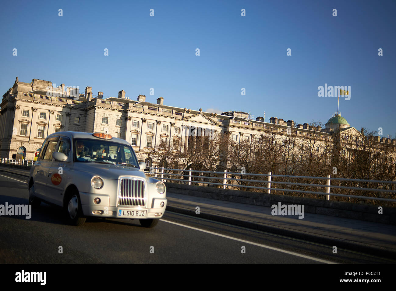Traditional silver color London taxi driving across the bridge in the city centre of London Stock Photo