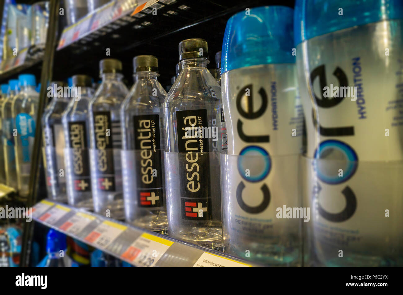Bottles of Essentia and other waters in a cooler in a convenience store in New York on Thursday, June 14, 2018. Essentia, one of players in the functional water space, has hired Credit Suisse to run an auction of the company hoping to attract a larger beverage brand such as PepsiCo or Nestle. Essentia claims superior hydration due to a proprietary method of ionizing the water. (Â© Richard B. Levine) Stock Photo