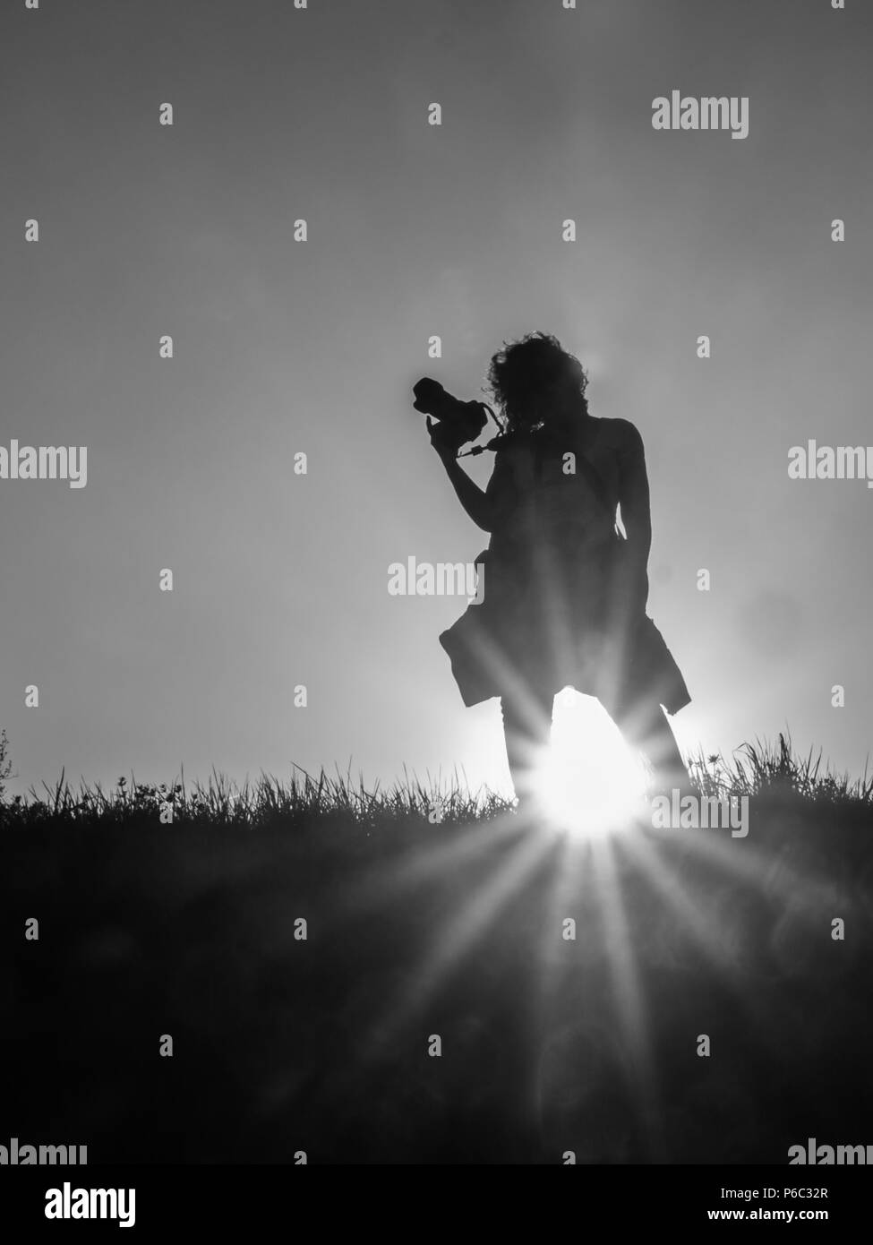 Silhouette women with photo camera during sunset time. Photographer. Stock Photo
