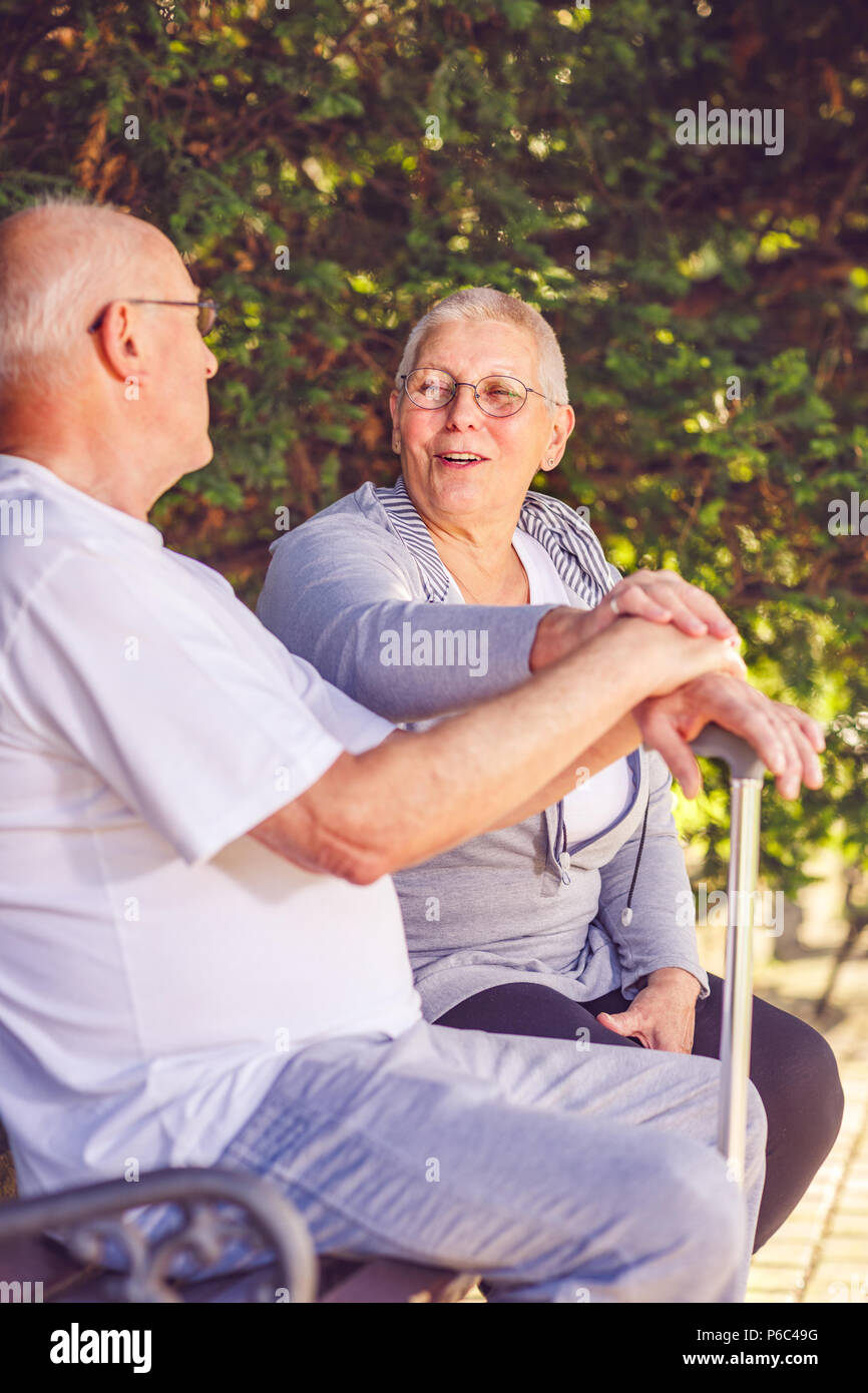 Relaxed senior couple sitting on a park bench Stock Photo
