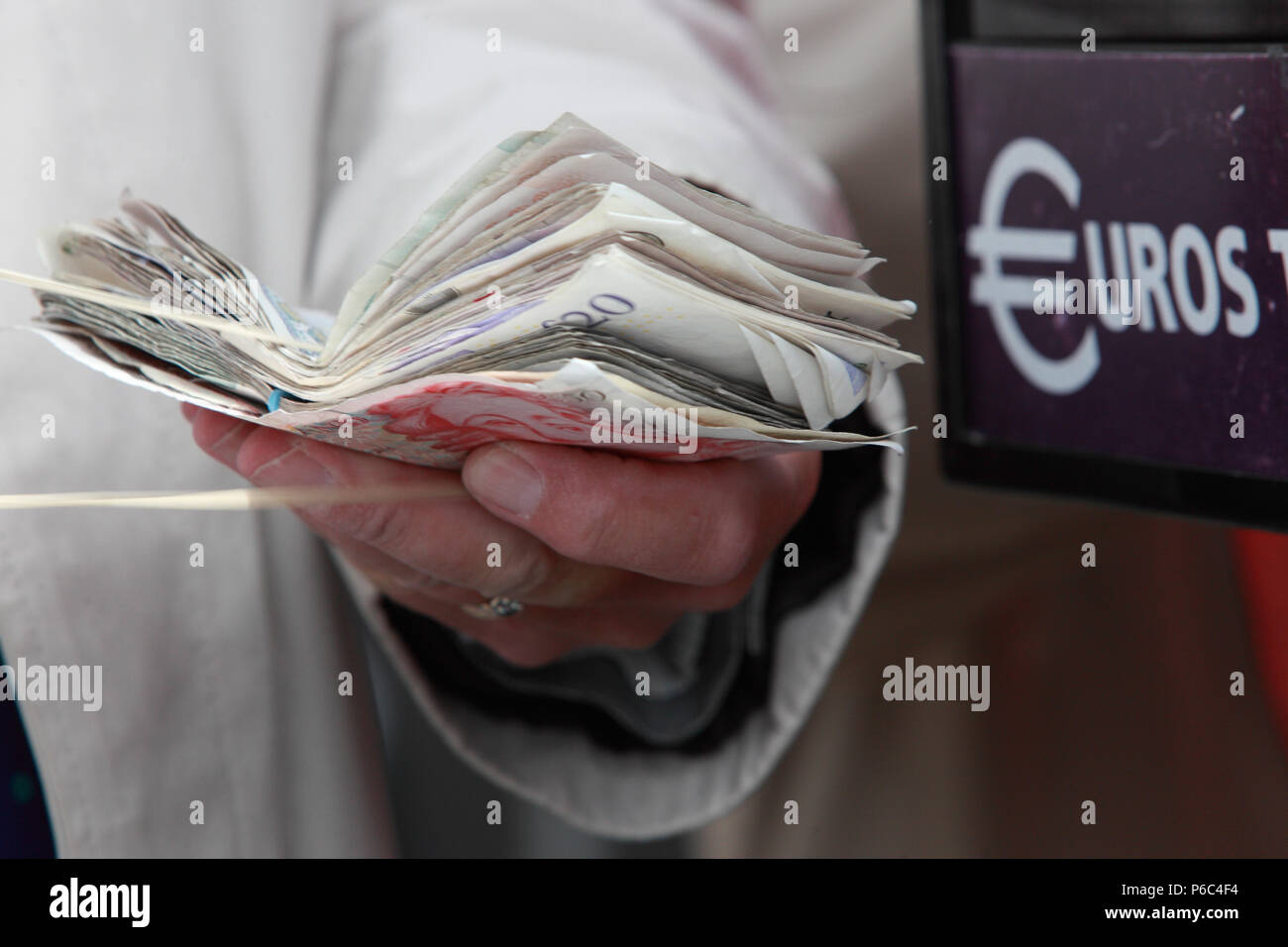 Ascot, UK, British pound notes are held in front of a euro change machine Stock Photo