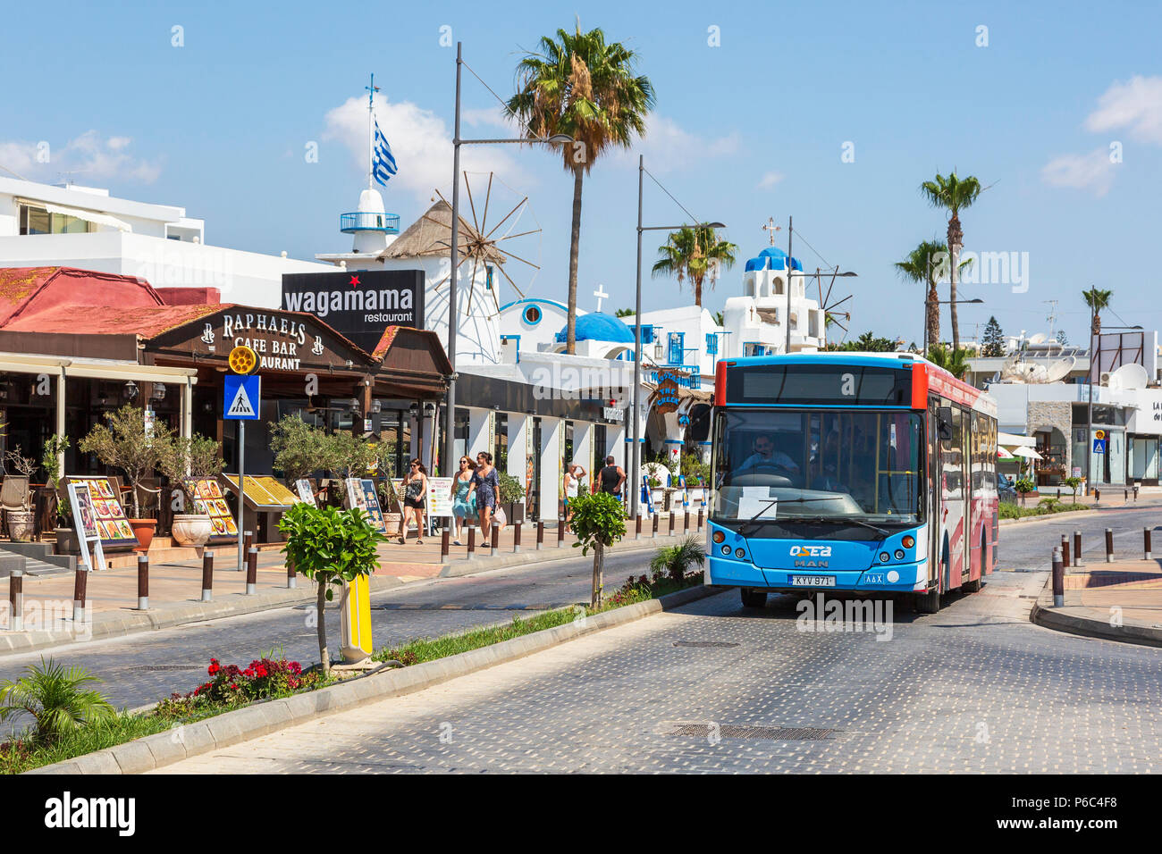 Public service bus driving on the main street in Ayia Napa, Cyprus Stock Photo