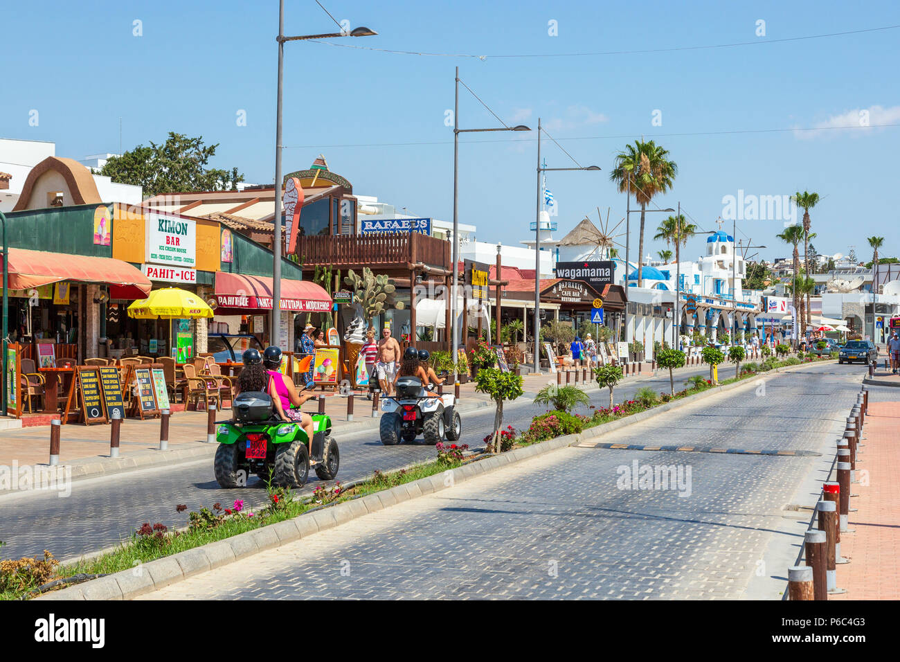 Street scene in Ayia Napa town, with tourists riding on 4x4 sand buggies, Ayia Napa, Cyprus Stock Photo