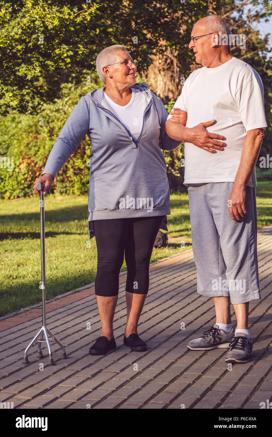 Romantic relationships- Happy senior couple walking through the park Stock Photo