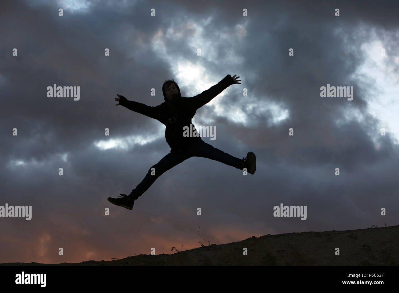 Wustrow, Germany - Silhouette, boy doing a splits in the air Stock Photo