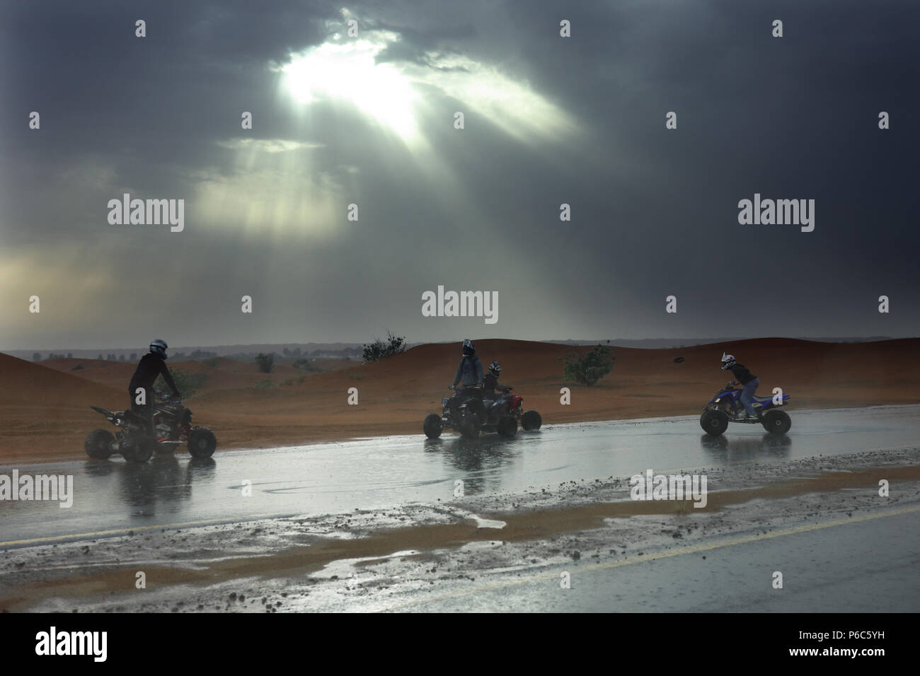 Dubai, United Arab Emirates, quad rider in the rain in the desert Stock Photo