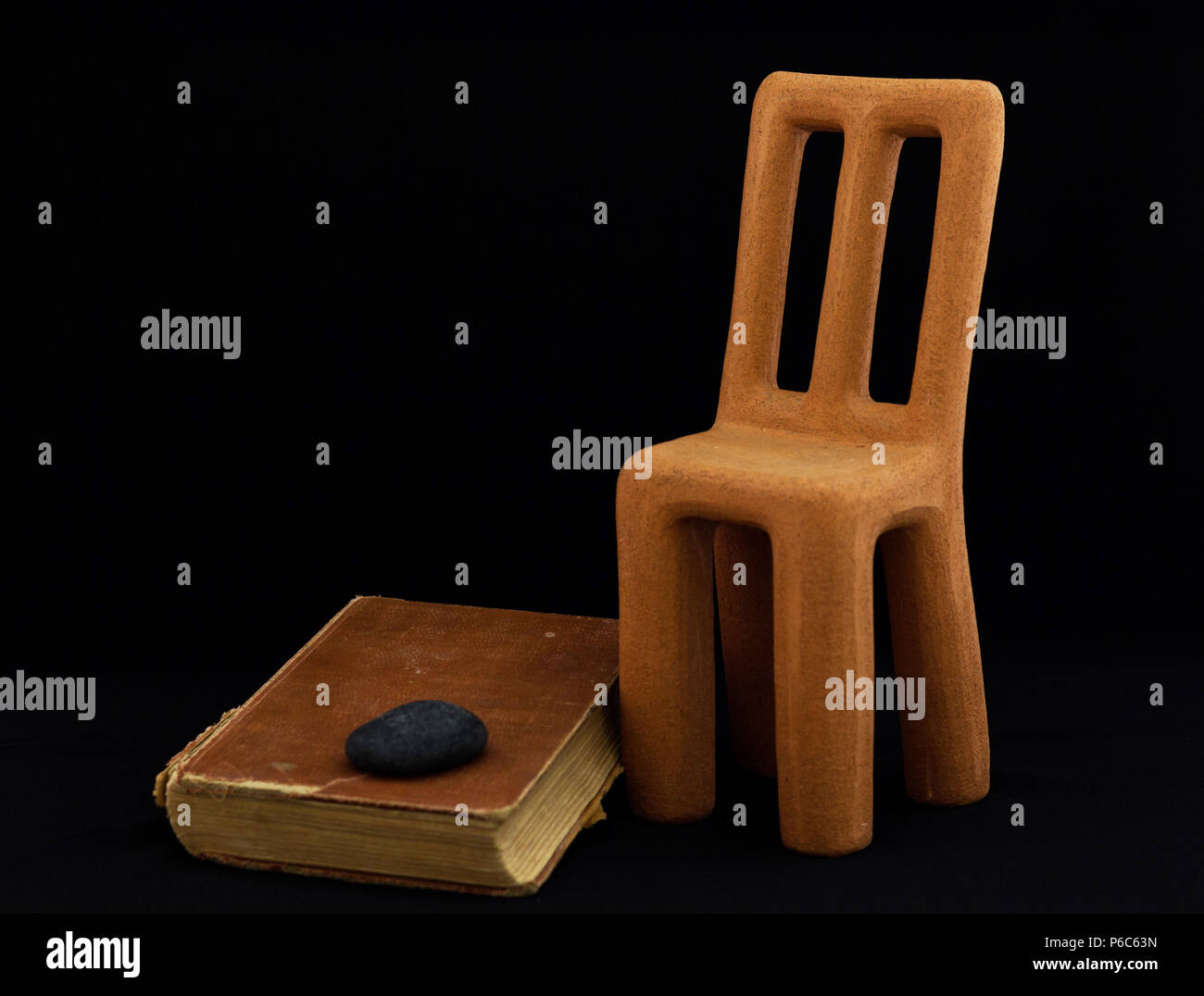 Clay chair, vintage book, black stone Stock Photo