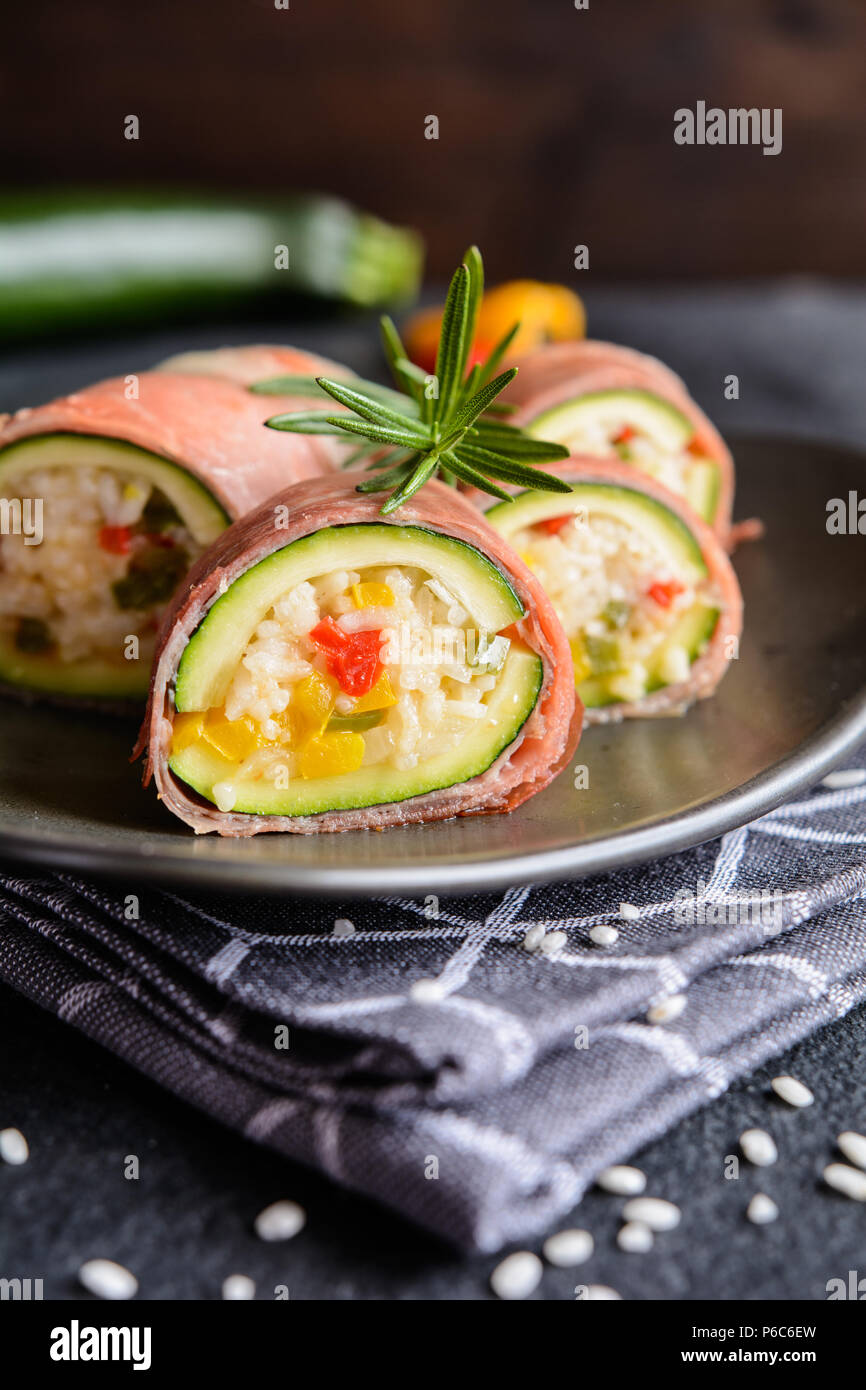 Roasted zucchini stuffed with rice, cheese, pepper and wrapped in Prosciutto slices Stock Photo