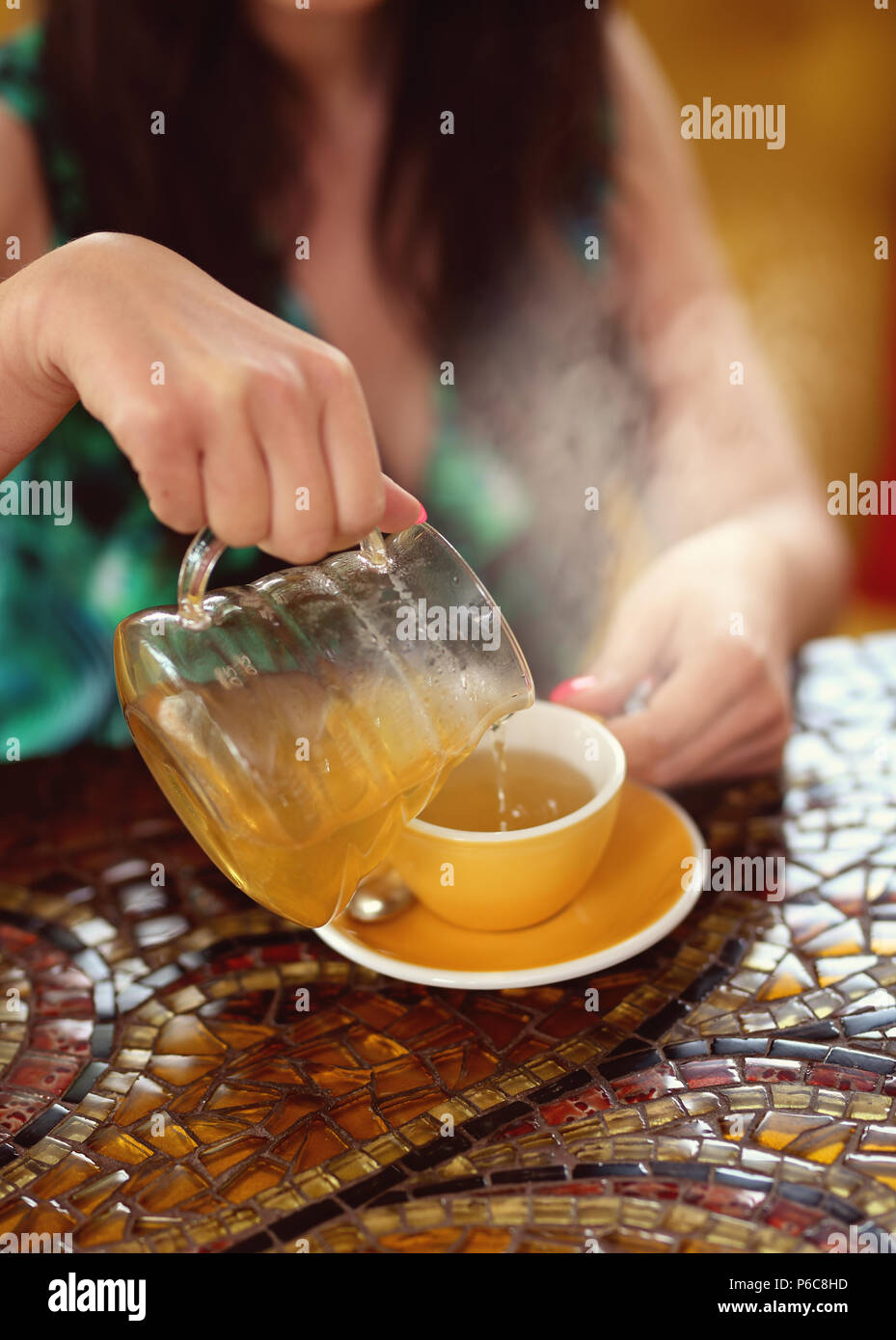 woman pours green tea into the cup Stock Photo