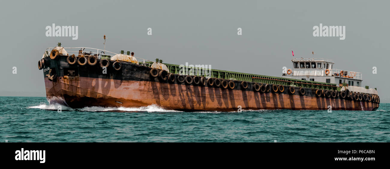 Small Feeder Boat known as barge carrying material for Mother vessel Stock Photo
