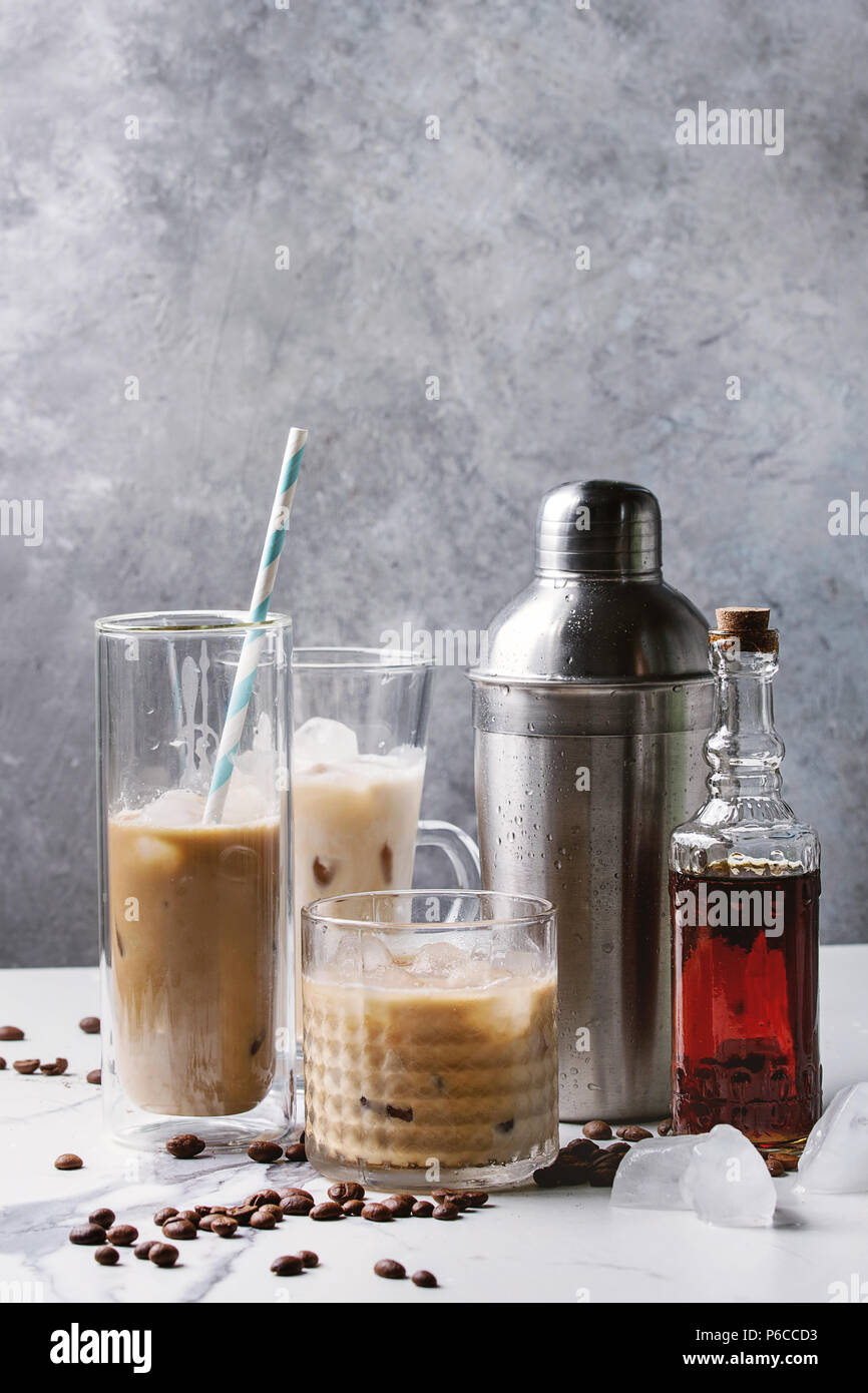https://c8.alamy.com/comp/P6CCD3/iced-coffee-cocktail-or-frappe-with-ice-cubes-and-cream-in-different-glasses-with-silver-shaker-bottle-of-rum-coffee-beans-around-on-white-marble-ta-P6CCD3.jpg