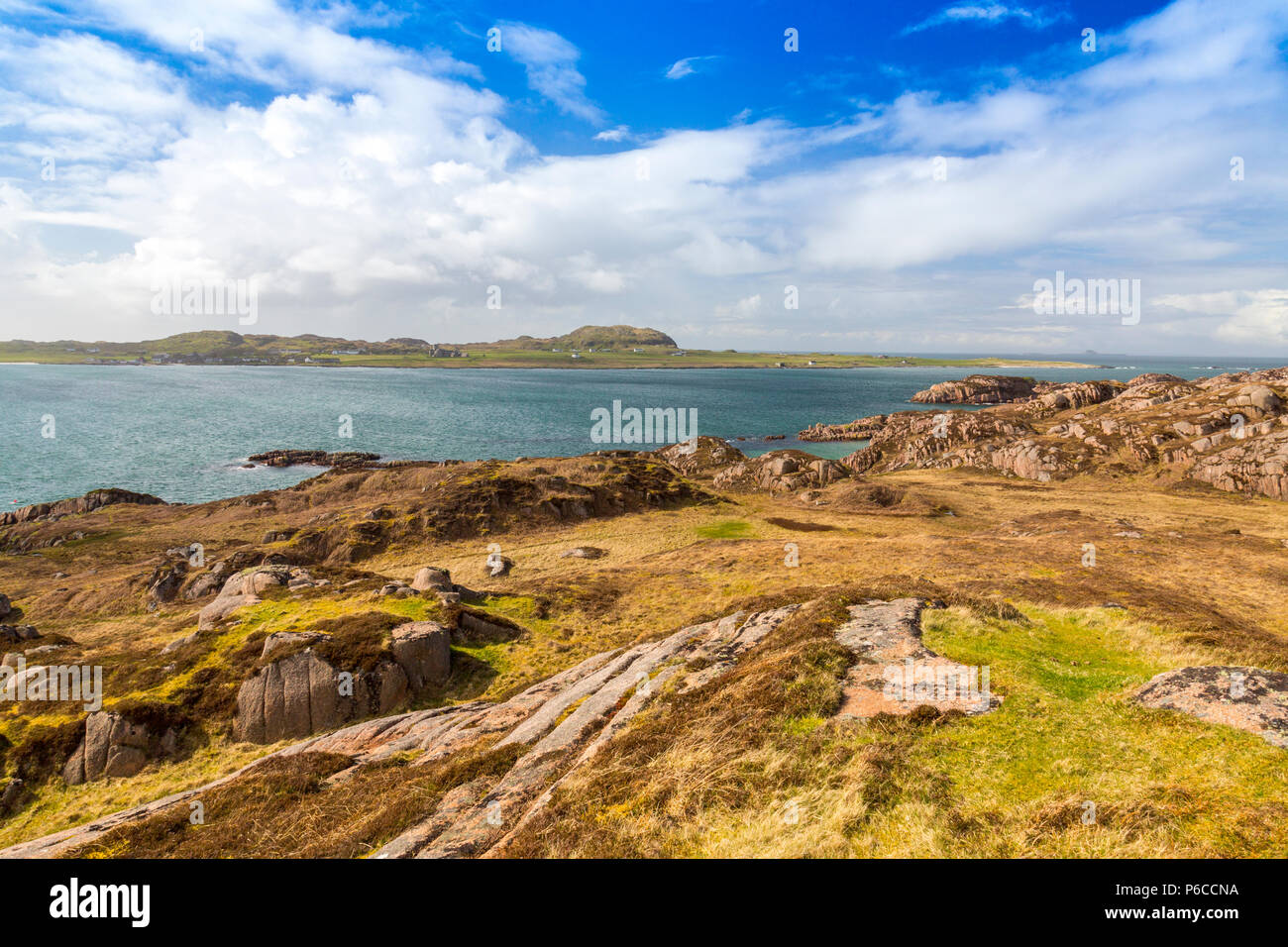 Looking across the Sound of Iona from the red granite rocks above Fionnphort on the Ross of Mull, Argyll and Bute, Scotland, UK Stock Photo