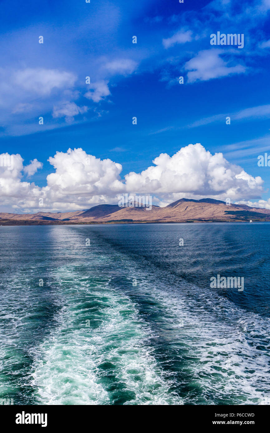 Towering cumulus clouds over the hills of Mull seen from the stern of the Mull - Oban ferry, Argyll and Bute, Scotland, UK Stock Photo